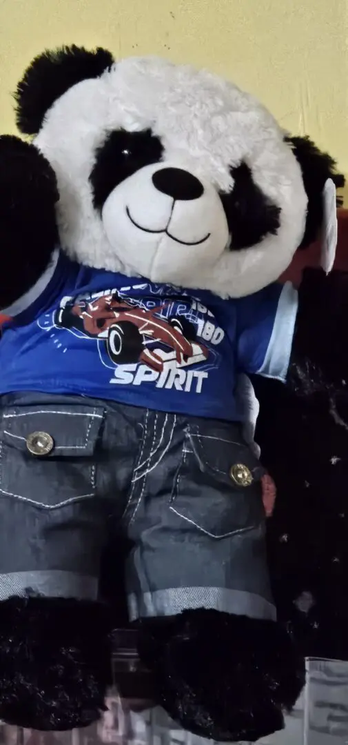 A stuffed animal wearing jeans and a t-shirt.